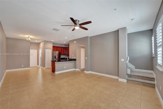 unfurnished living room featuring ceiling fan and light tile patterned flooring