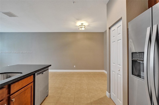 kitchen with sink, light tile patterned floors, and stainless steel appliances