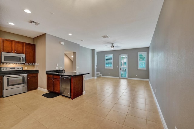 kitchen with sink, ceiling fan, light tile patterned floors, kitchen peninsula, and stainless steel appliances