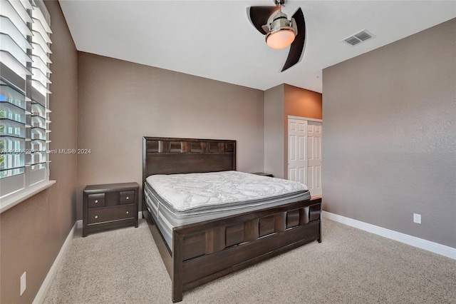 carpeted bedroom featuring ceiling fan and a closet