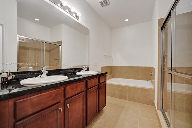 bathroom with tile patterned floors, vanity, and shower with separate bathtub