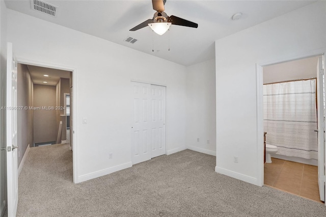 unfurnished bedroom with ensuite bathroom, ceiling fan, light colored carpet, and a closet