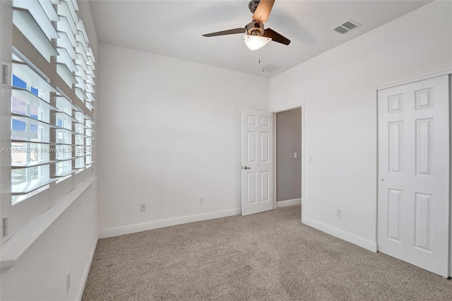 unfurnished bedroom with ceiling fan and light carpet