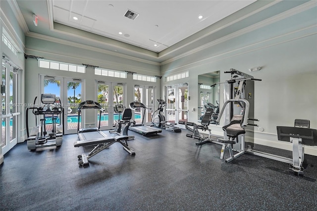 exercise room featuring a raised ceiling, a wealth of natural light, and french doors