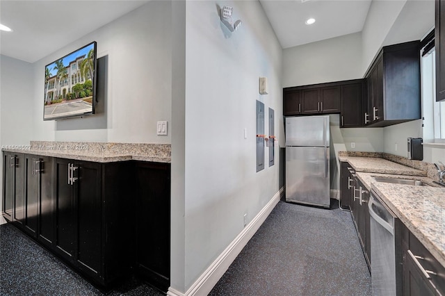 kitchen featuring light stone counters, sink, and appliances with stainless steel finishes