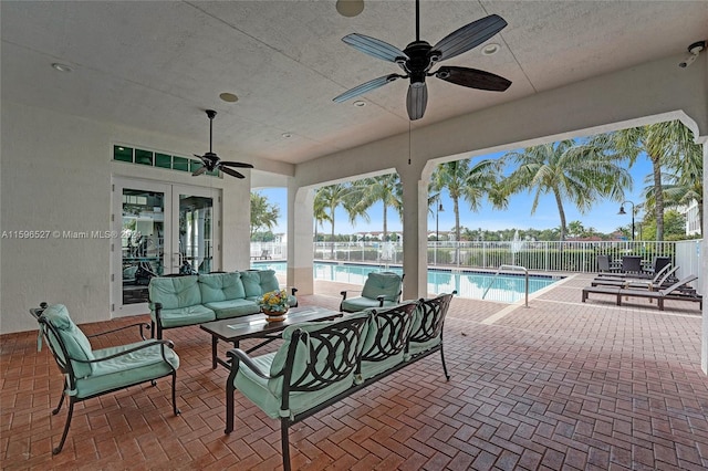 view of patio / terrace featuring french doors, an outdoor hangout area, a fenced in pool, and ceiling fan