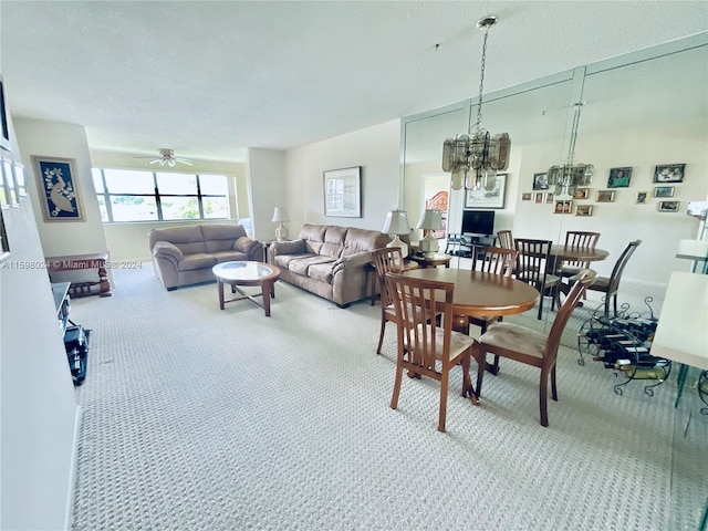 dining room with carpet and ceiling fan with notable chandelier