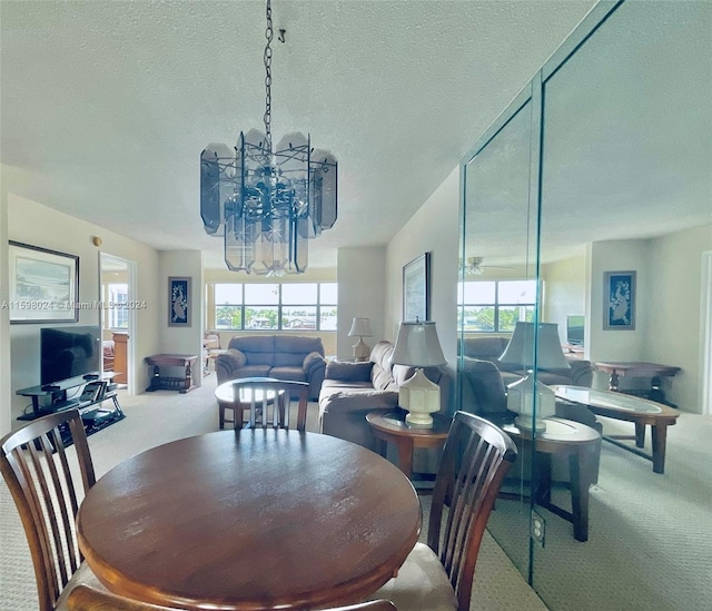 carpeted dining area with a textured ceiling and an inviting chandelier