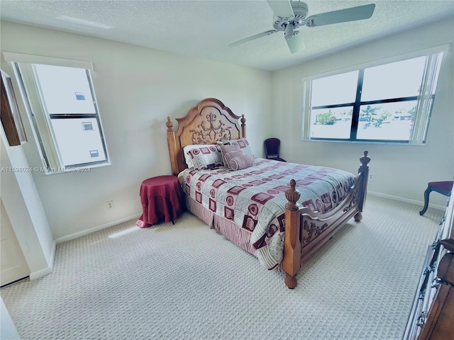 carpeted bedroom featuring a textured ceiling and ceiling fan