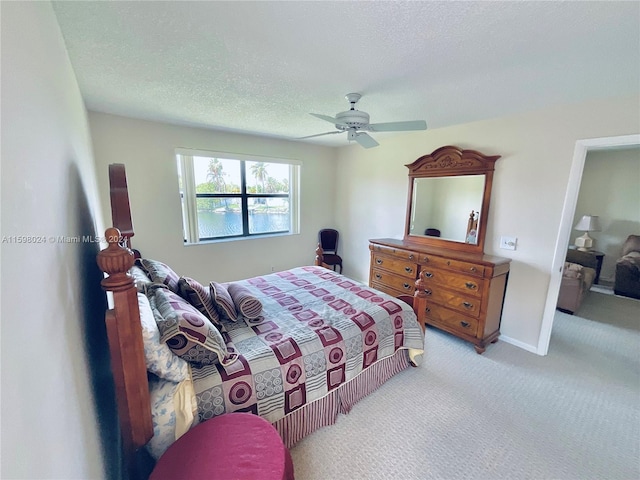 bedroom with light carpet, a textured ceiling, and ceiling fan