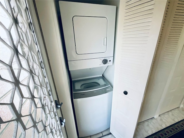 washroom featuring stacked washer / drying machine