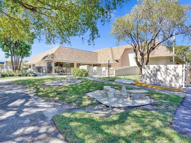 view of front of house with a patio and a front yard