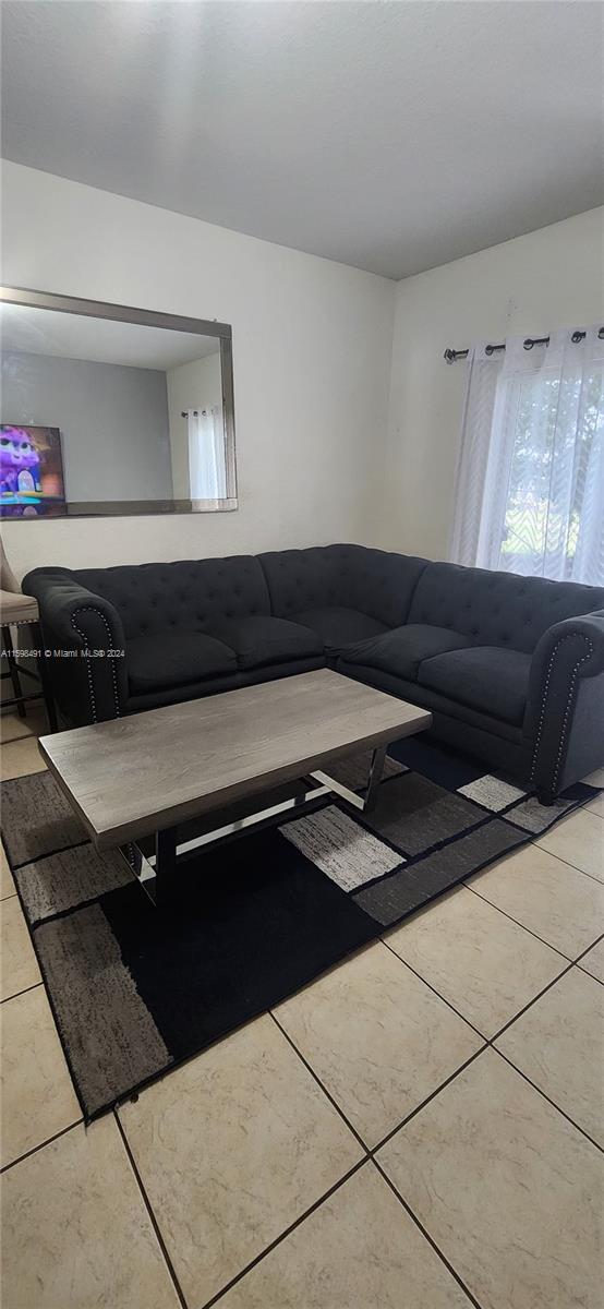 unfurnished living room featuring light tile patterned floors