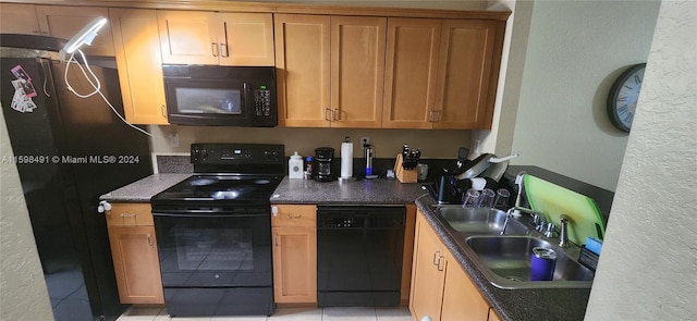 kitchen with light tile patterned floors, sink, and black appliances