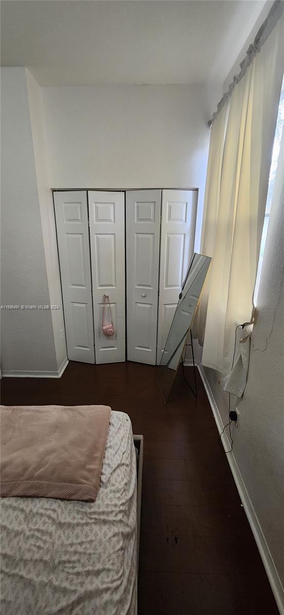 bedroom featuring dark wood-type flooring and a closet