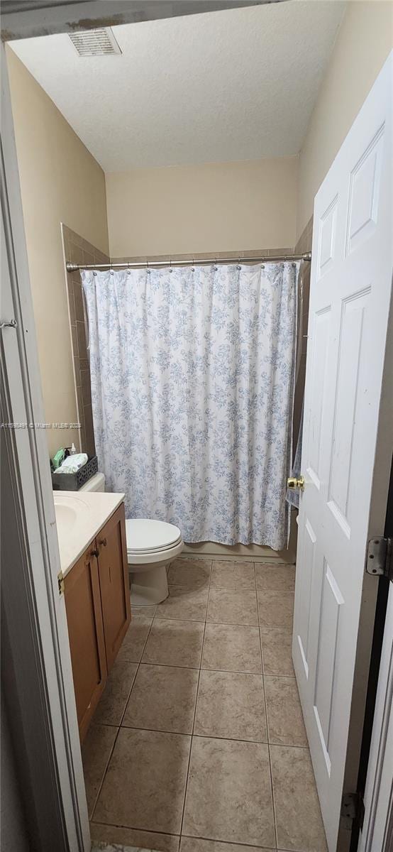 bathroom featuring tile patterned floors, vanity, and toilet