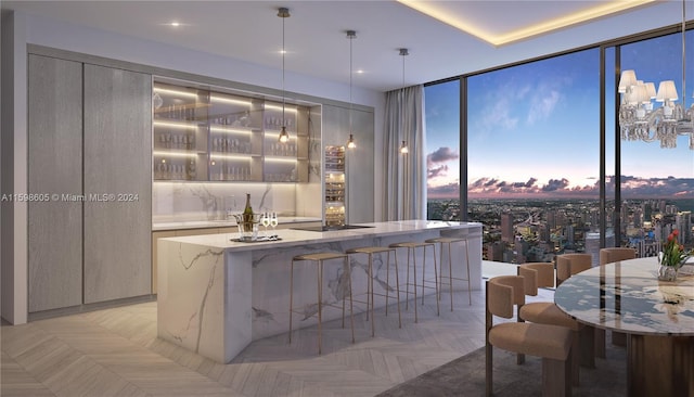 bar featuring floor to ceiling windows, light stone countertops, black electric stovetop, light parquet floors, and pendant lighting