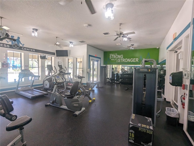 exercise room with a textured ceiling, a wealth of natural light, and ceiling fan