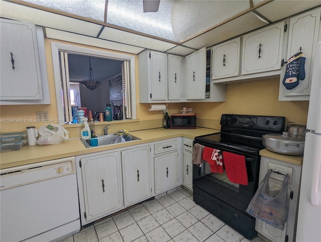 kitchen with white cabinetry, sink, light tile patterned flooring, and black appliances