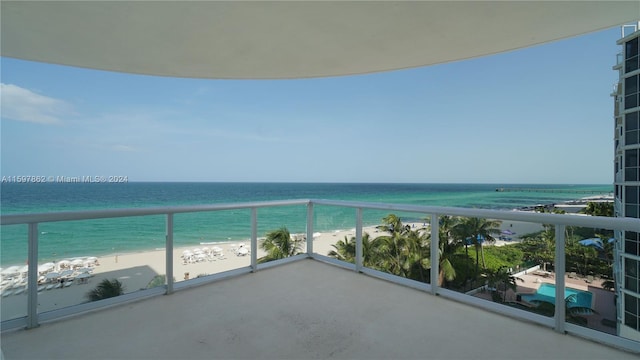 balcony featuring a beach view and a water view