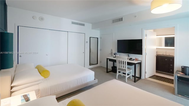 bedroom featuring light colored carpet and a closet