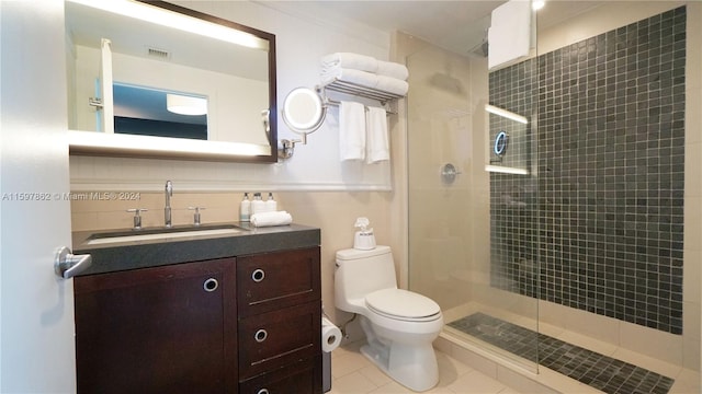 bathroom featuring backsplash, toilet, tile floors, walk in shower, and vanity