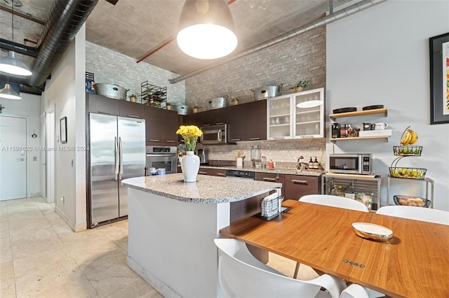 kitchen with backsplash, dark brown cabinets, light tile patterned floors, and stainless steel appliances