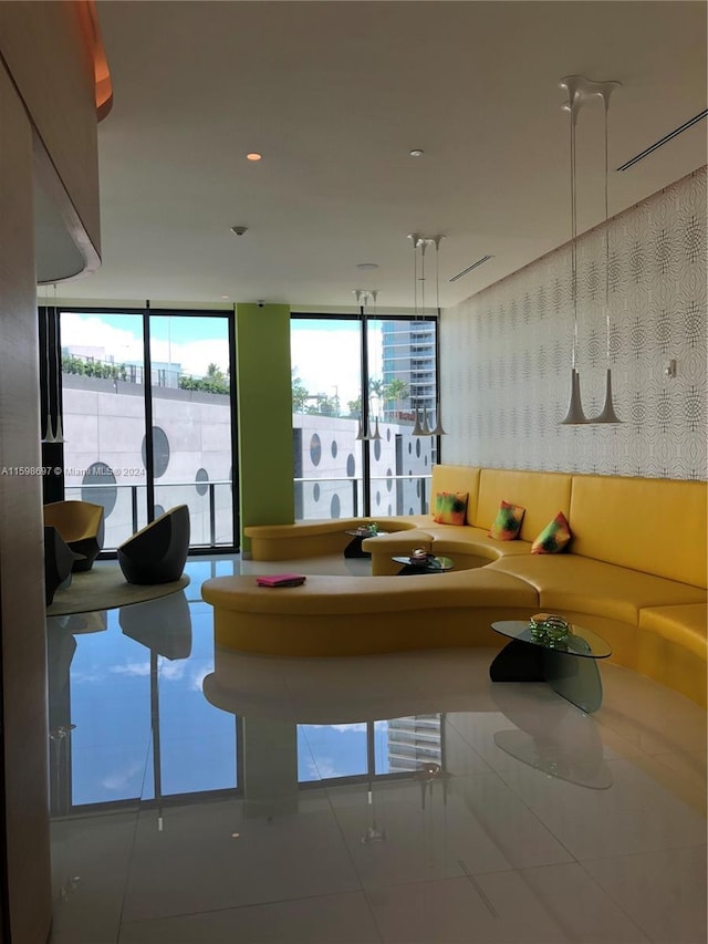 tiled living room with a healthy amount of sunlight and floor to ceiling windows