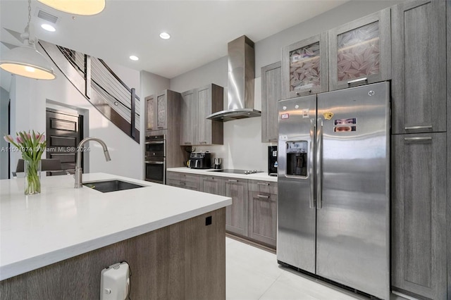 kitchen featuring appliances with stainless steel finishes, light tile patterned floors, wall chimney exhaust hood, and sink