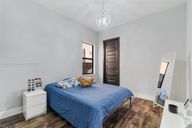 bedroom featuring dark hardwood / wood-style floors and an inviting chandelier