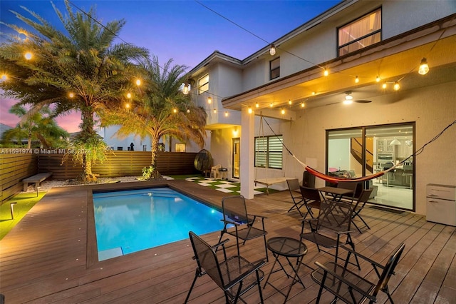 pool at dusk featuring a deck