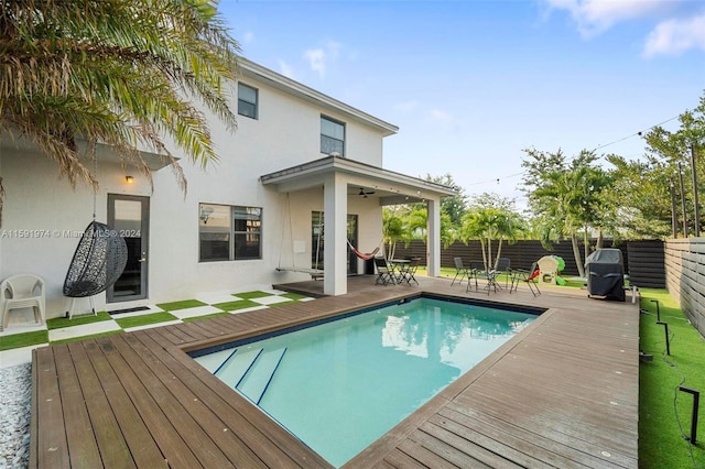 view of pool with a wooden deck and ceiling fan