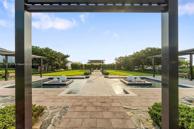 view of property's community featuring a lawn, a pergola, and a patio area