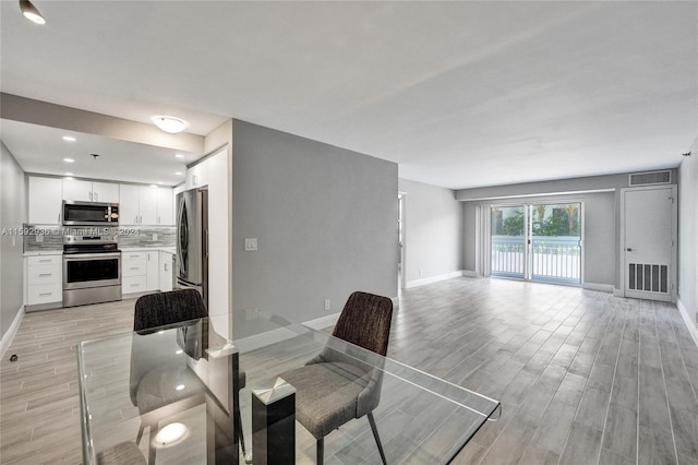 dining space with light hardwood / wood-style floors