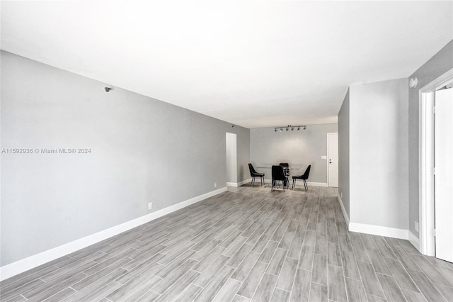 empty room featuring rail lighting and light hardwood / wood-style flooring