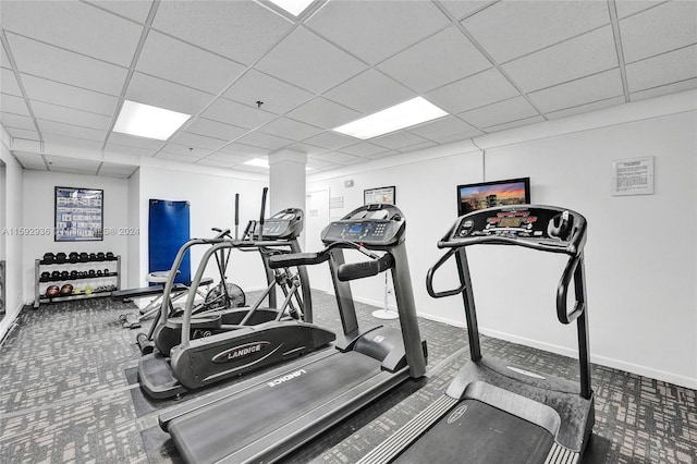 exercise room with carpet flooring and a drop ceiling