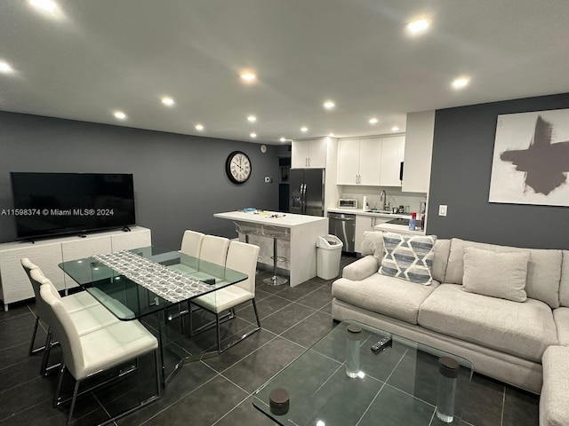 living room featuring dark tile flooring and sink