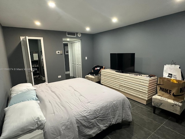 bedroom featuring dark tile floors and a closet