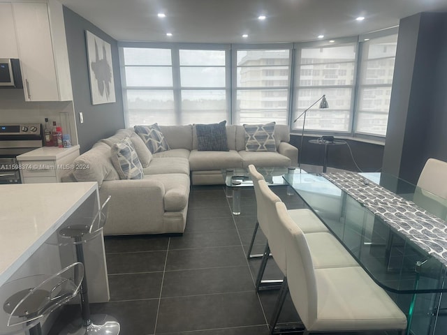 living room with expansive windows and dark tile floors