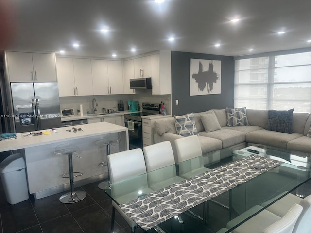 living room featuring sink and dark tile floors