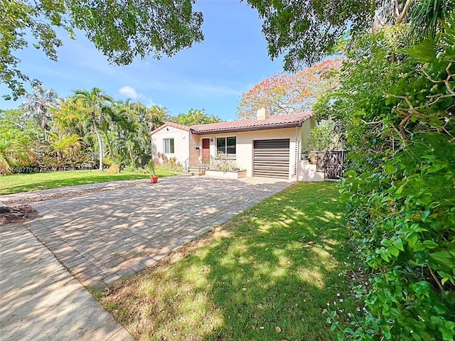 view of front of property with a garage and a front lawn