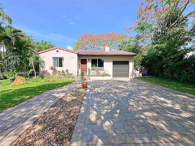 mediterranean / spanish-style house with a garage and a front lawn