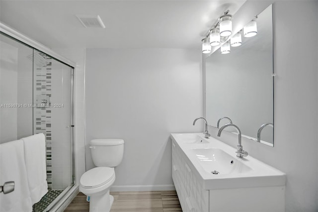 bathroom with toilet, a shower with shower door, and vanity