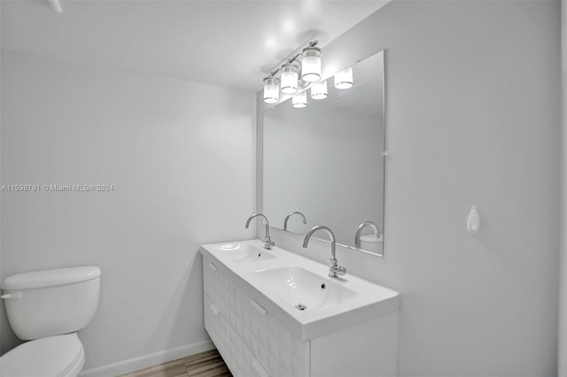 bathroom featuring toilet, vanity, and hardwood / wood-style flooring