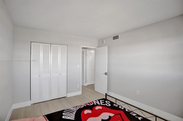 bedroom with light wood-type flooring and a closet