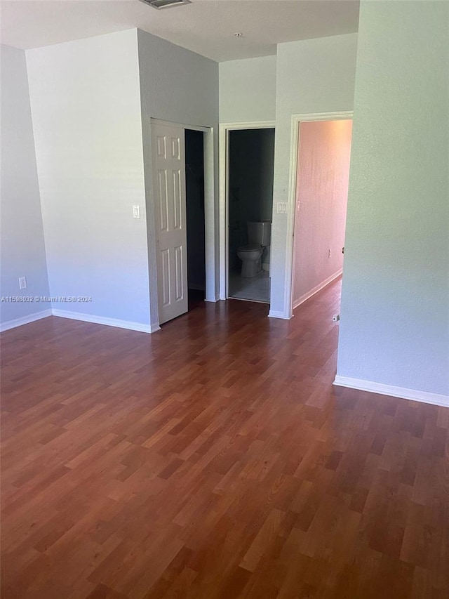 empty room with dark hardwood / wood-style flooring