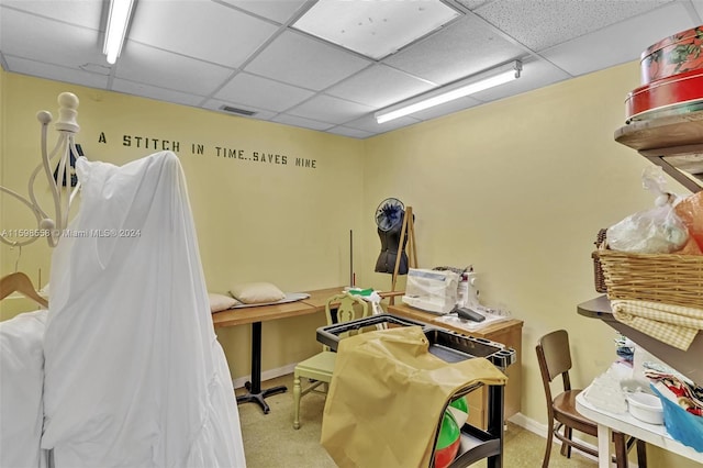 miscellaneous room with a paneled ceiling and light carpet