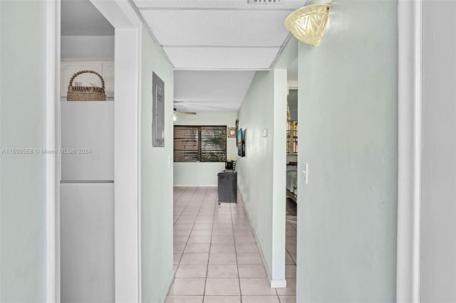 hall with light tile patterned floors and a drop ceiling