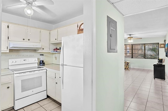 kitchen featuring white appliances, electric panel, ceiling fan, light tile patterned floors, and white cabinetry