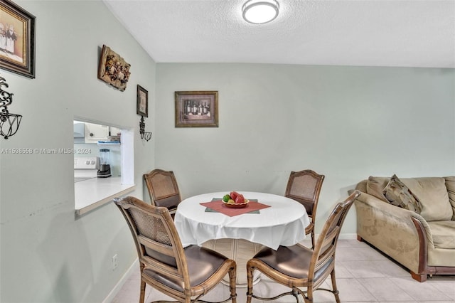 dining room with light tile patterned floors and a textured ceiling